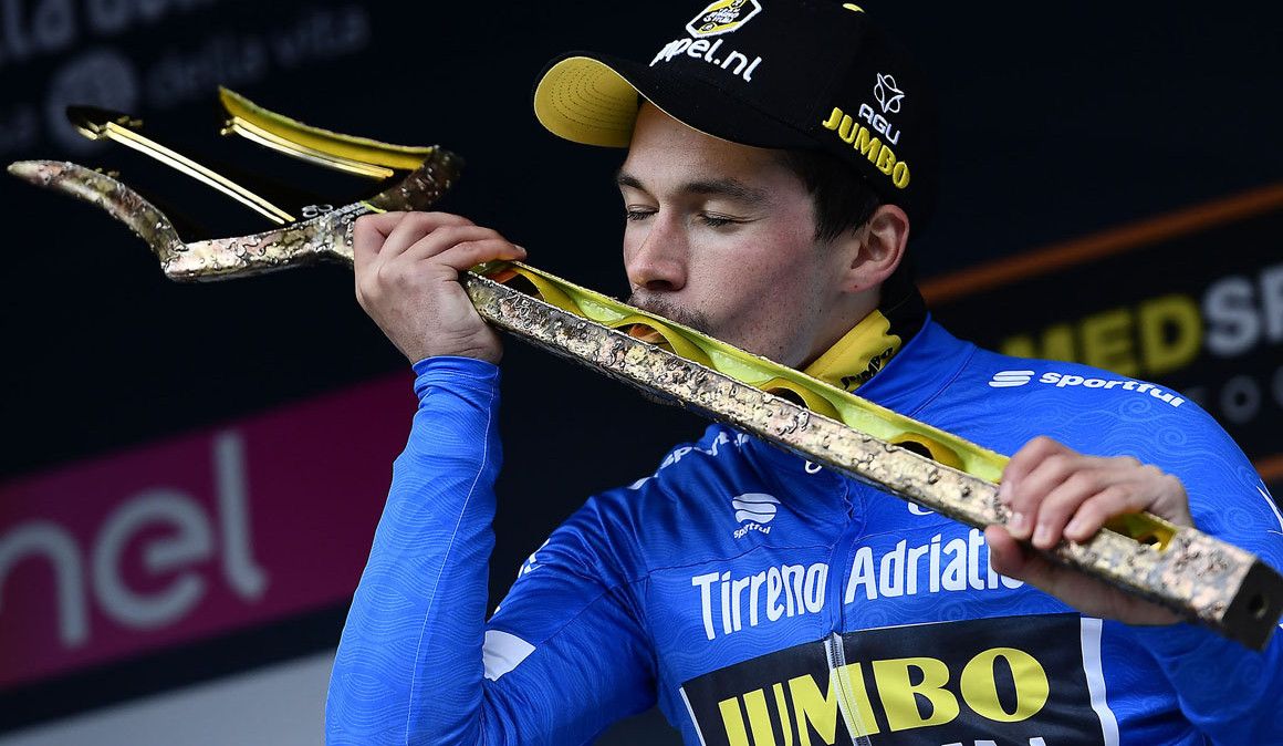 Primoz Roglic, ganador de la Tirreno-Adriático 2019, besando el tradicional tridente de Netuno que recibe el ganador de la carrera de los dos mares. 