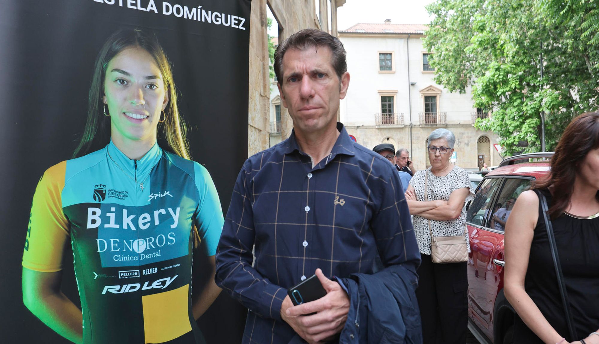 Juan Carlos Domínguez, padre de Estela, posa junto a un retrato de su hija en la primera sesión del juicio por el atropello mortal de la joven ciclista