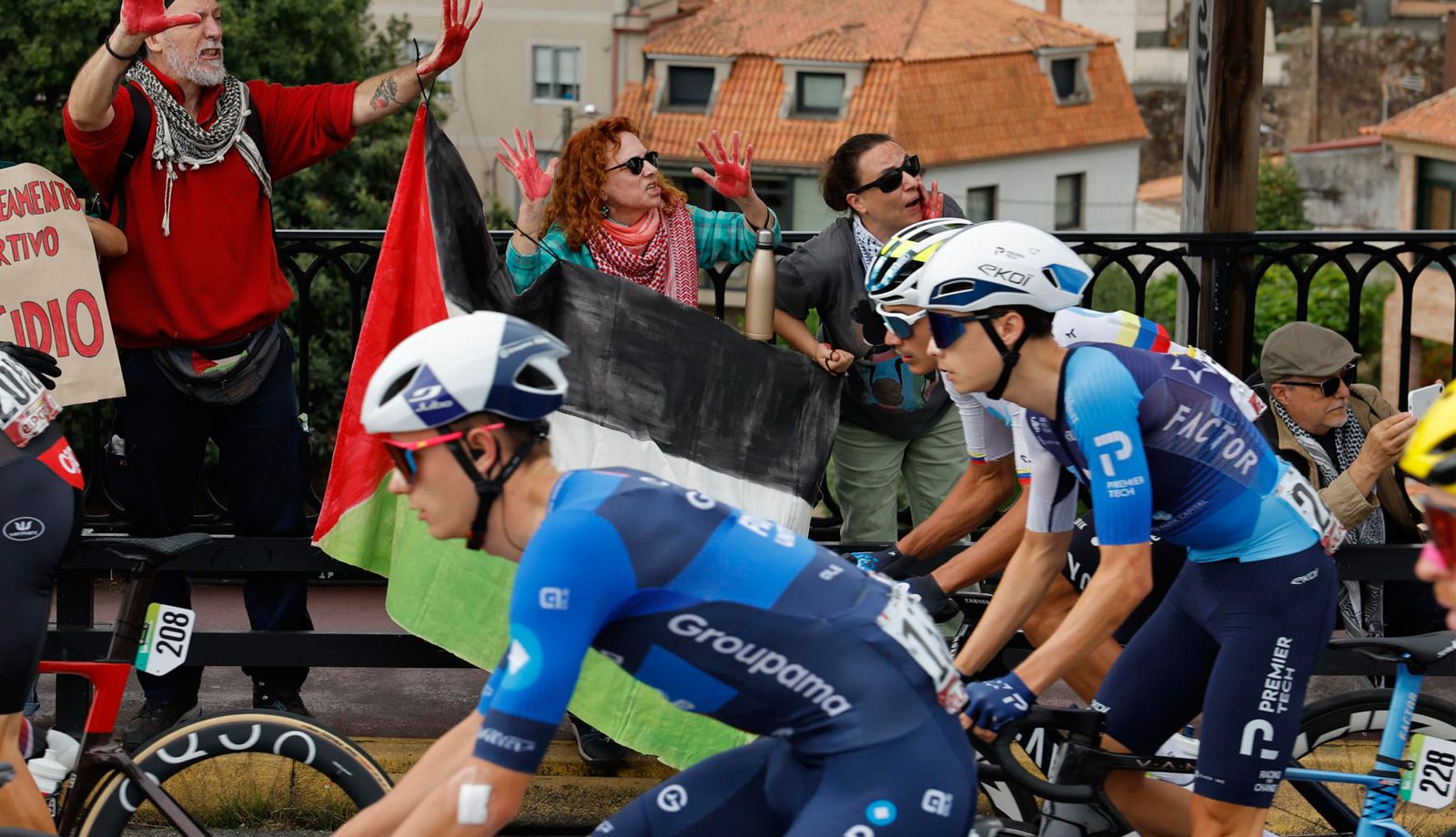 Un ciclista del Israel Premier Tech pasa ante las protestas propalestina durante la etapa 16 de la Vuelta a España.