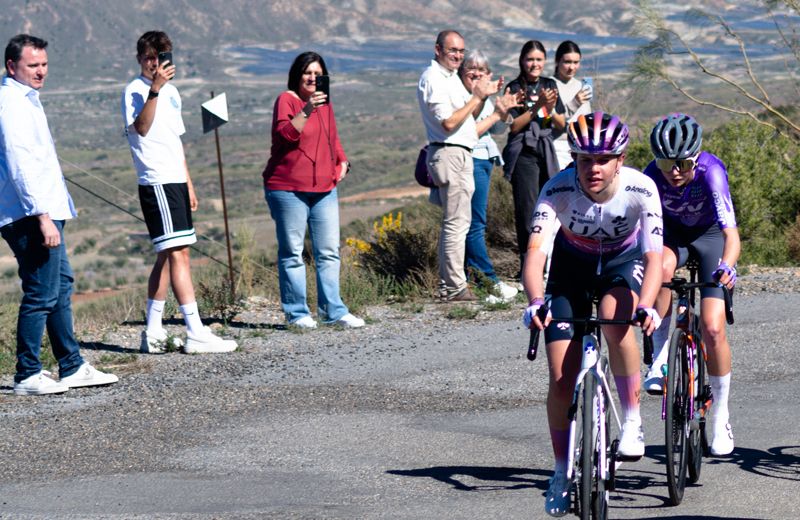 En primer plano, Celia Torres (UAE Team ADQ Devo); al fondo, con camiseta blanca y pantalón negro, su hermano Pablo.