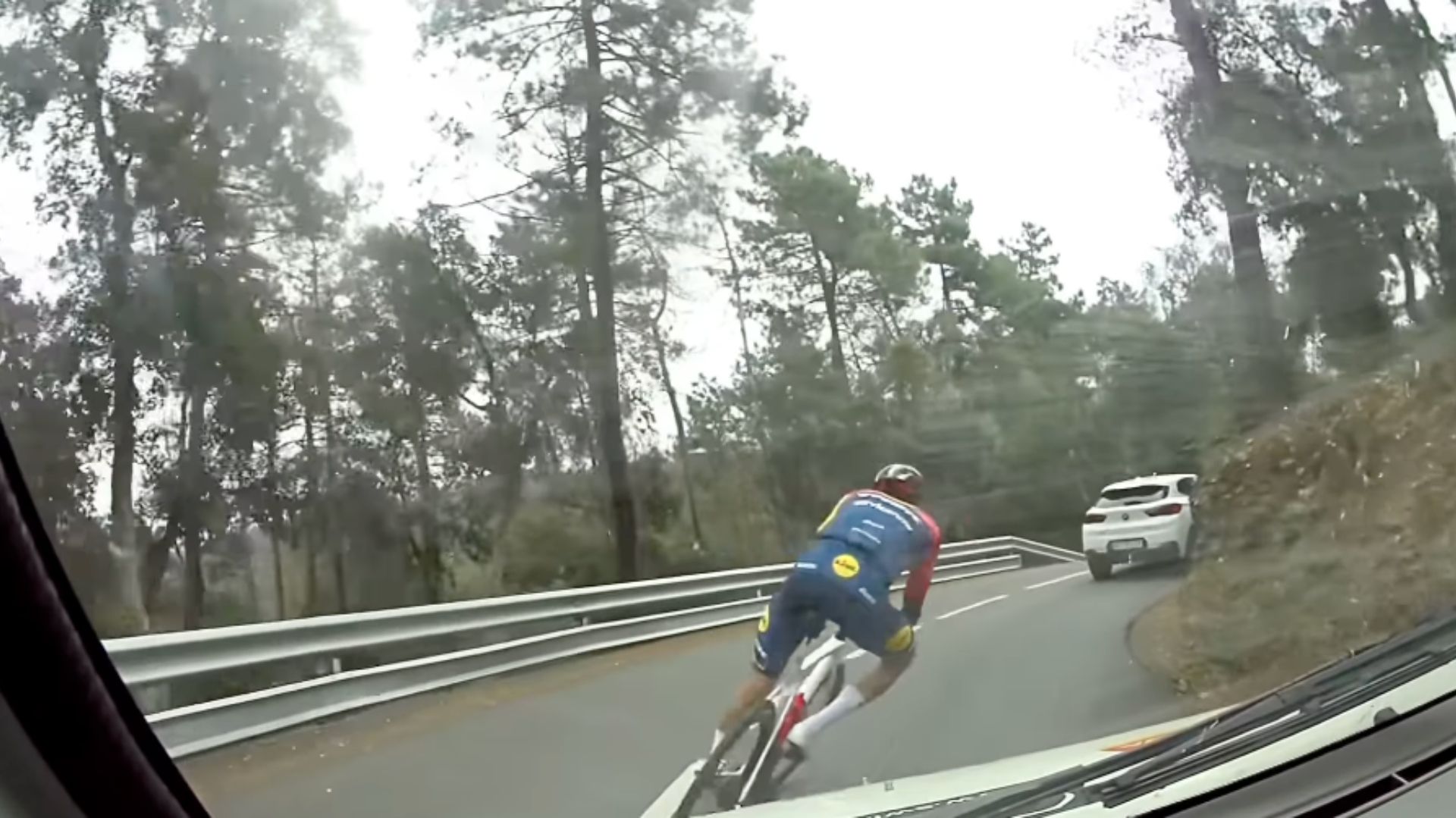 Aleix Espargaró adelantando en bici a gran velocidad a varios vehículos con el maillot del Lidl Trek